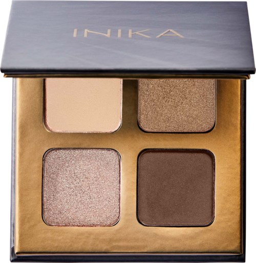 A makeup palette with four eyeshadow shades, in a box with a partially open lid, labeled INIKA.