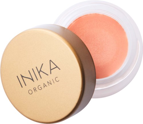 A round container with a beige lid labeled 'INKA ORGANIC', open to show peach-colored cream inside.