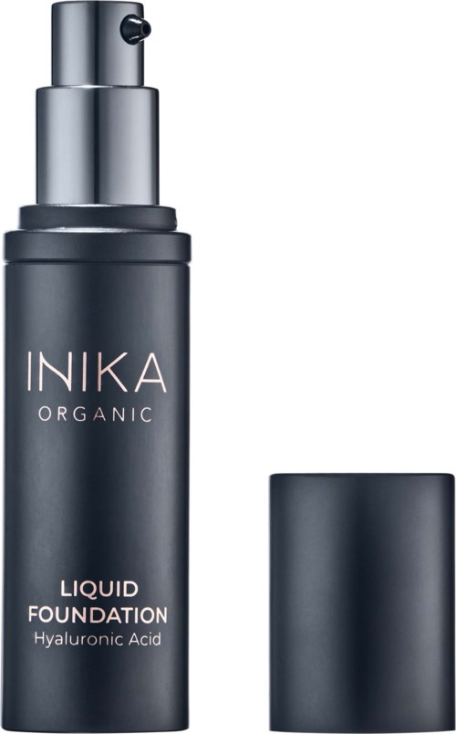 A black bottle of INIKA Organic liquid foundation with a pump, labeled with ingredients and brand name.