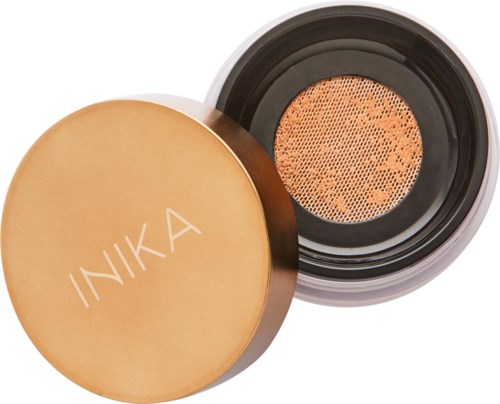 A container with a golden lid that says INIKA. Inside is a sponge for applying makeup.