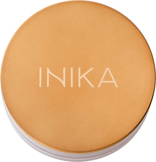 A round cosmetic item with the brand name INIKA on top, in a light orange color.