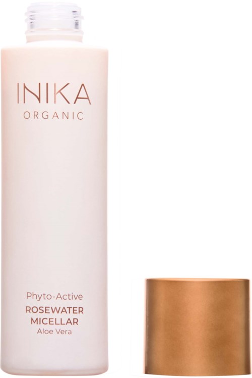 A white bottle of INIKA Organic Rosewater Micellar with a gold cap beside it.