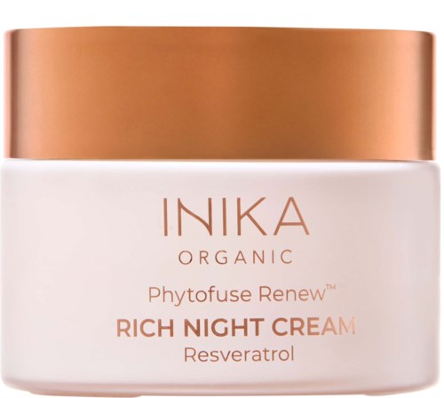 A jar of Inika Organic cream with a white body and a metallic bronze lid.