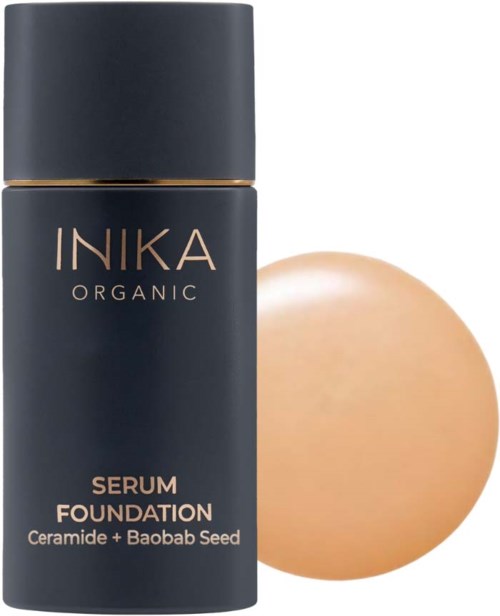 Tummansininen pullo, jossa lukee 'INIKA ORGANIC Serum Foundation', ja sen vieressä beige meikkivoide.