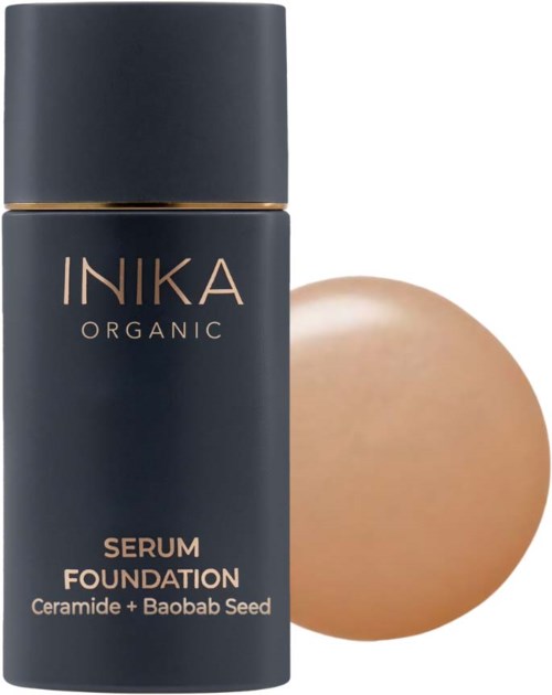 Tumma pullo, jossa lukee INIKA Organic Serum Foundation keramiikalla ja Baobab-siemenellä, ja sen vieressä vaaleanruskea ympyrä.