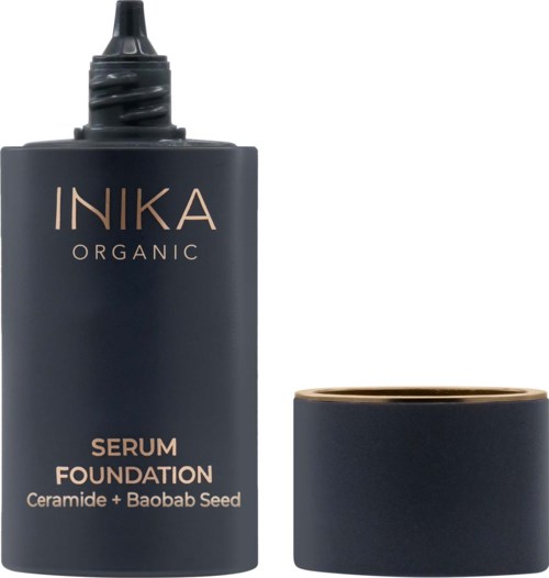 Tummansininen Inika Organic -seerumipohja, jonka vieressä on kansi. Pullo on teksteiltään kullanvärinen ja valkoinen.