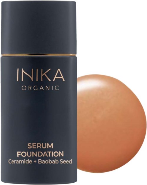 Tumma pullo, jossa lukee 'INIKA Organic Serum Foundation', ja ruskea meikkisieni sen vieressä.