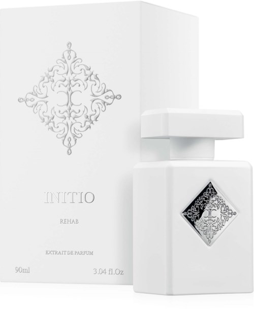 Eine weiße Parfümflasche mit kunstvollem schwarzen und silbernen Design und eine passende weiße Verpackung mit Logo.