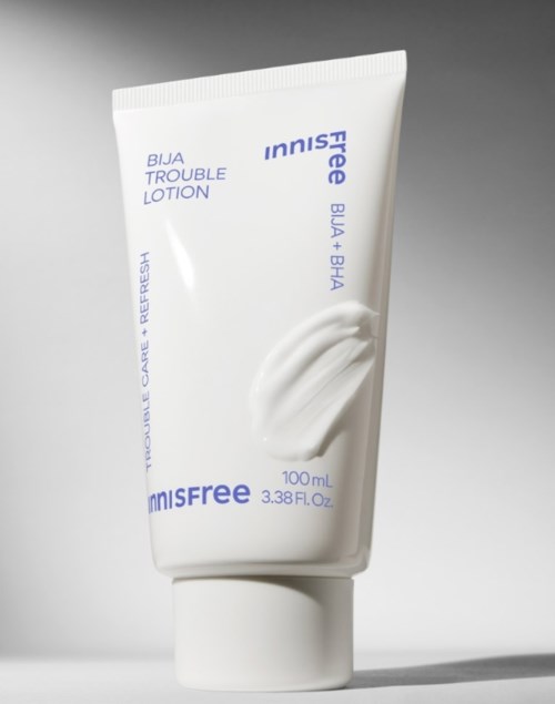 Witte lotiontube met 'Innisfree Bija Trouble Lotion' erop, tegen een grijze achtergrond. 100 ml. Eenvoudig ontwerp en tekst.