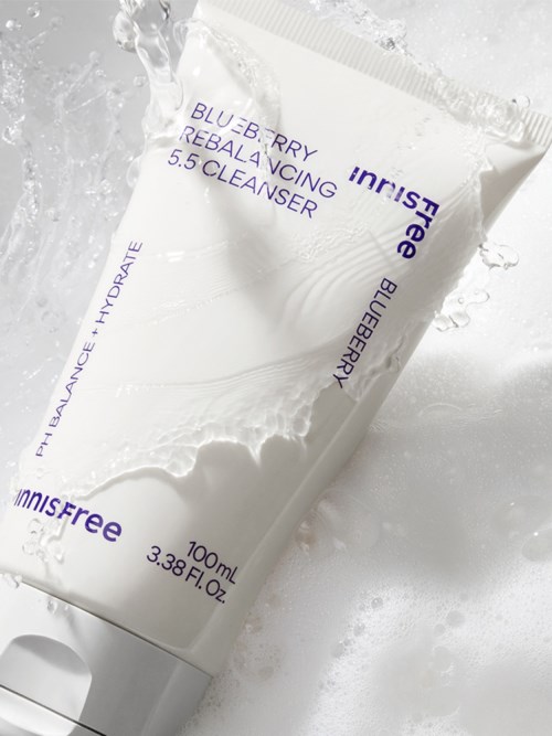 Een witte tube van INNISFREE Blue Berries Rebalancing 5.5 Cleanser met water die er omheen spat.