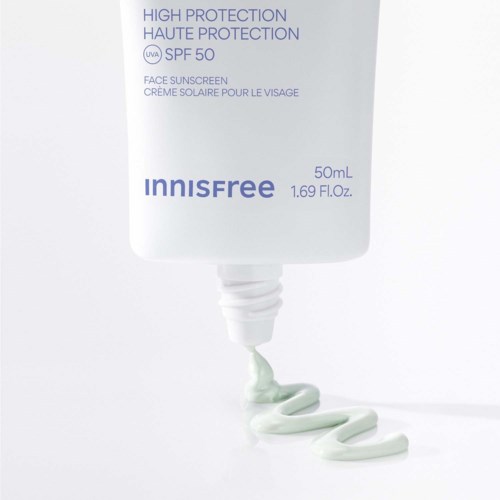 En vit tub med Innisfree solskyddsmedel med blå text, som pressar ut ljusgrön kräm i en spiral.