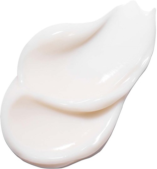 Två klickar av vit hudvård eller lotion på en vit bakgrund.