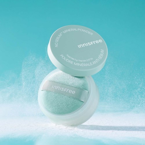 En rund behållare med Innisfree-mineraldpuder med ett ljust blått lock, delvis öppen som visar pudret inuti.