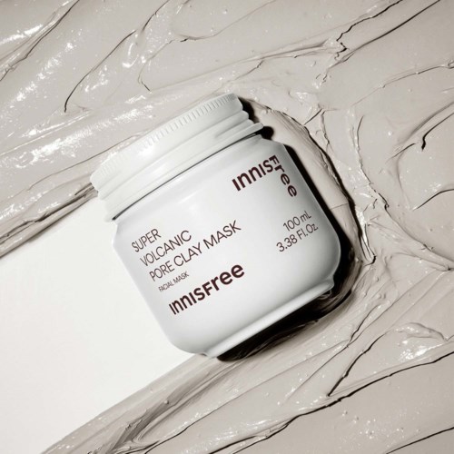 En vit burk märkt INNISFREE Super Volcanic Pore Clay Mask på en krämig yta.