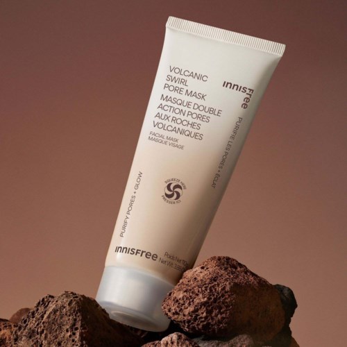 En tub med Innisfree volcanic pore mask vilar på vulkansk sten mot en brun bakgrund.