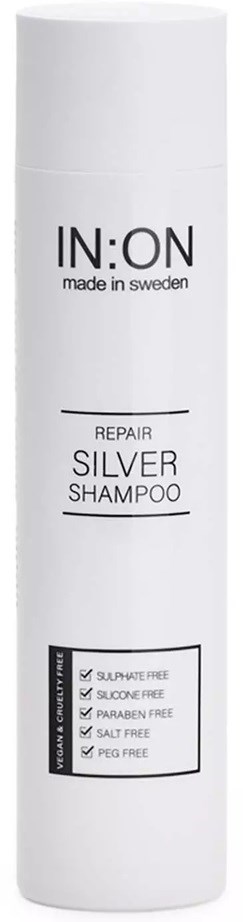 A tall white bottle labeled IN:ON Repair Silver Shampoo, free from sulfates, silcones, parabens, salt, and PEG.