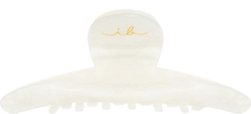 Ein weißer Haarspang mit einem kleinen, gebogenen Goldlogo oben. Sie hat Zähne, um Haare festzuhalten.