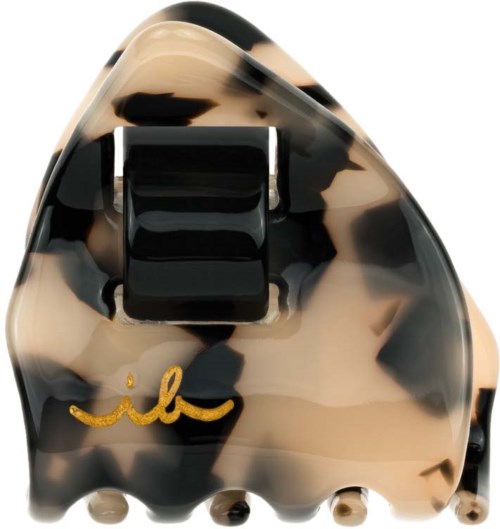 A tortoise shell pattern hair clip with a black clip and golden signature logo.
