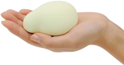 Ein Hand hält einen großen, weißen, ovalen Gegenstand, möglicherweise ein Ei oder ein weiches Objekt.