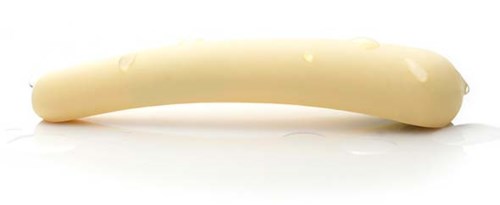 Ein weißer, gebogener Käse-Stick mit sichtbaren Löchern, auf einer weißen Oberfläche.