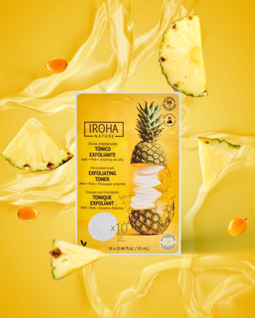Een felle gele box met ananasontwerp voor exfoliërende toner, omgeven door ananaspartjes en vloeistofspatten.