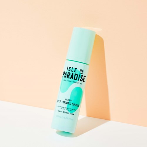 A light blue bottle labeled 'Isle of Paradise' with a cap, standing on a white and peach background.