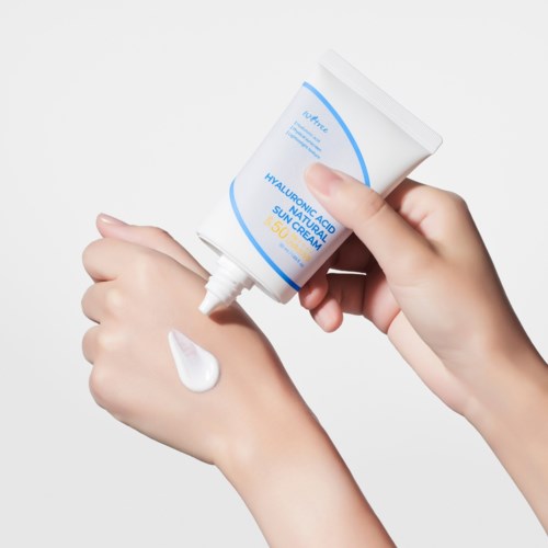 Persoon knijpt witte crème uit een tube op de hand. De tube is voor huidverzorging.