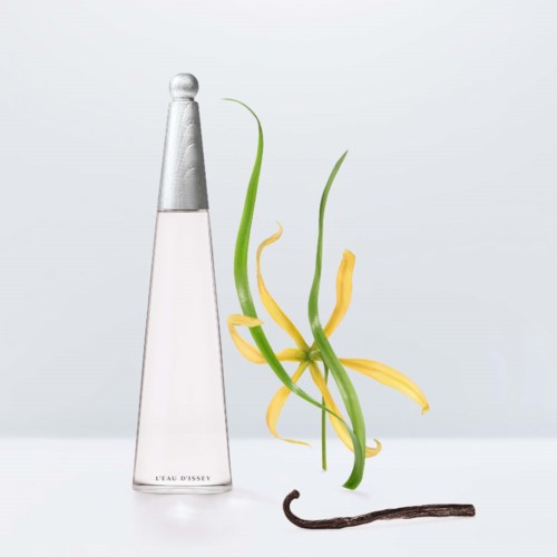 Een parfumfles met het label 'L'EAU D'ISSEY' naast een gele bloem, groene stelen en een vanilla bean.