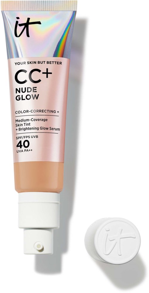 A tube of IT CC+ Nude Glow foundation with a cap nearby, featuring a shiny, rainbow-like background and pink packaging.