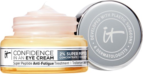 A jar of eye cream labeled with anti-fatigue and super peptide ingredients, with a silver lid and pastel pink cream.