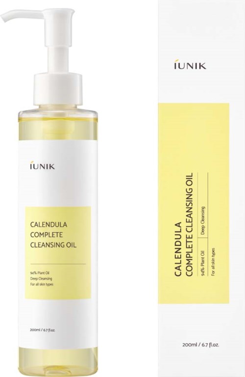 Een doorzichtige fles met pomp, label IUNIK calendula reinigingsolie, naast de doos met vergelijkbare gele en witte kleuren.
