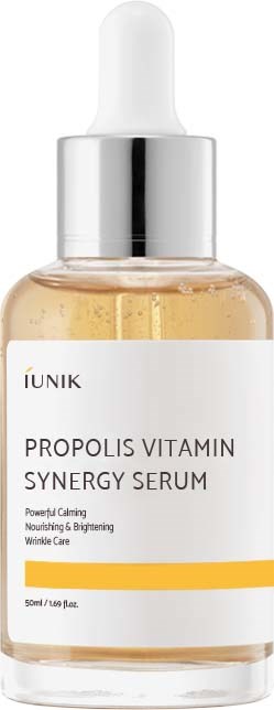 Een doorzichtige fles met pipettendop bevat Propolis Vitamin Synergy Serum. Label zegt dat het kalmeert, voedt en rimpels vermindert.