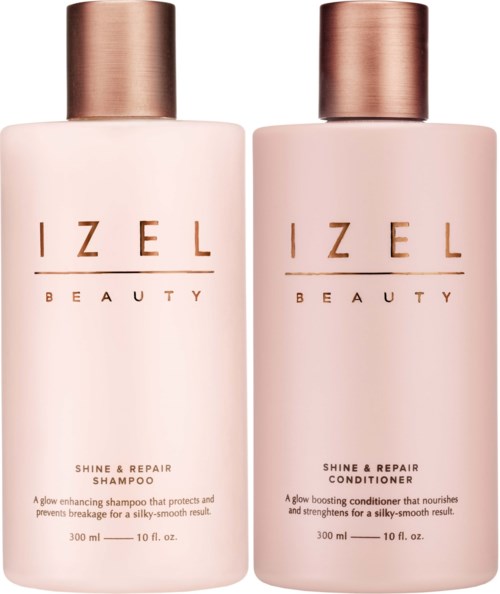 Twee flessen IZEL Beauty haarproducten, shampoo en conditioner, met roségouden deksels en lichtroze flessen.