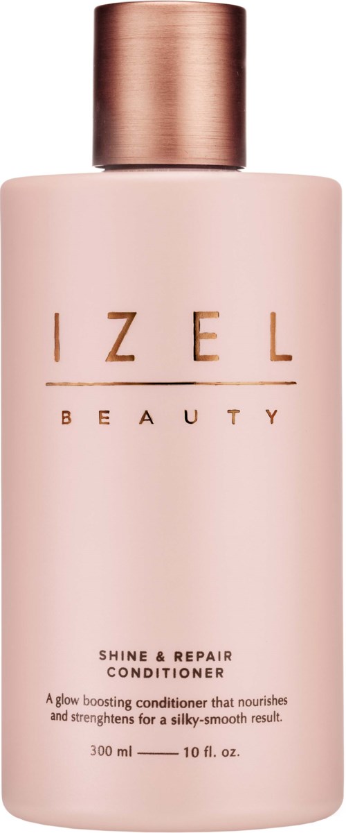 Een roze fles met een roségouden deksel, gelabeld 'IZEL BEAUTY Shine & Repair Conditioner.'