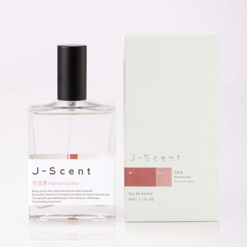 Glasparfymflaska med svart lock bredvid en vit box märkt J-scent och Hanasakiake Scent of Jeanne.