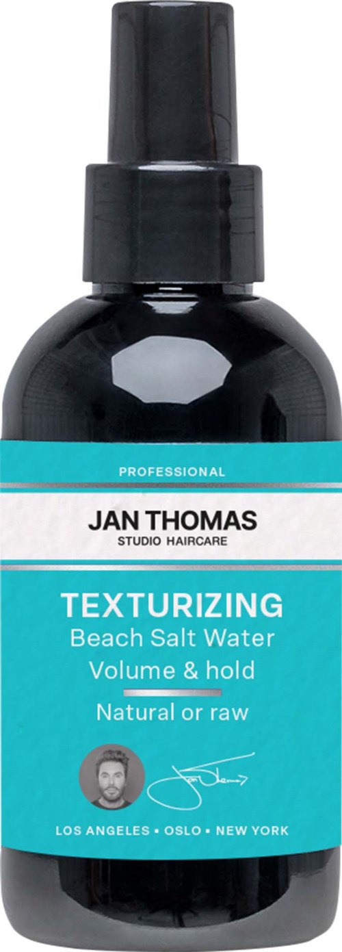 A black spray bottle labeled 'Texturizing Beach Salt Water' for hair, with a blue and black design.