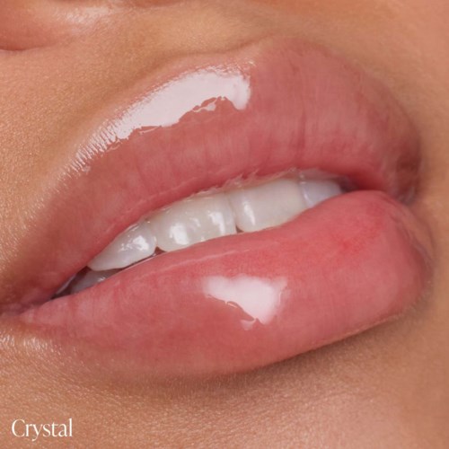 Close-up of lips with glossy, pinkish color and visible teeth. The skin around is smooth.