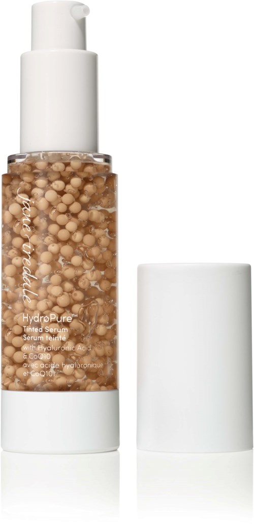 En tydlig flaska med vit lock innehållande små beige bollar, troligen en hudvårdsprodukt, utan lock.