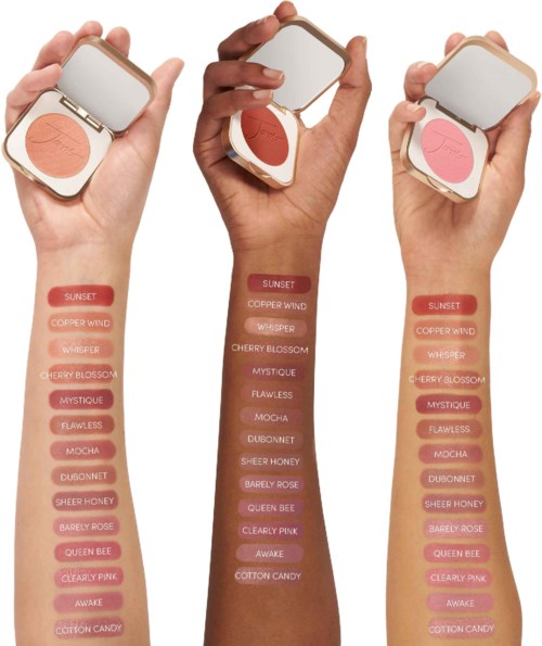 Tre händer håller makeup-compactfickor, varje med olika nyanser av rouge från rosa till brunt.