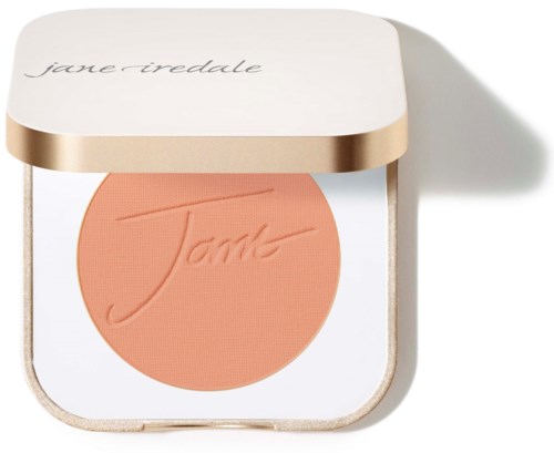En kompakt med peachfärgad blush och vitt och guldlock, märkt 'Jane Iredale.'