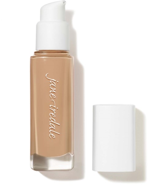 A bottle of foundation with a white cap and light beige liquid inside. The label says "Jade Riddle."