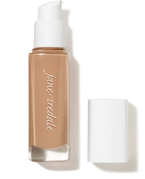En flaska med flytande foundation med vit lock och beige kropp med namnet "Jane Iredale" skrivet på den.
