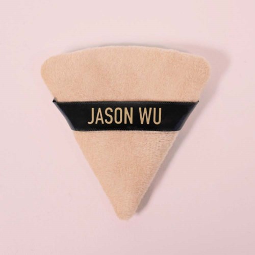 Ett beige filtmärke i form av en triangel med en svart rand i mitten, med texten "JASON WU".