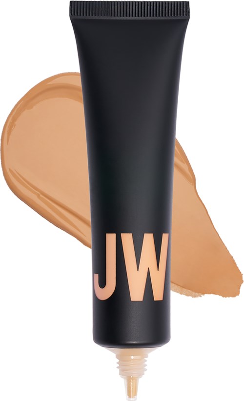 En svart tub med beige bokstäver 'JW' och beige foundation spridd bakom den.