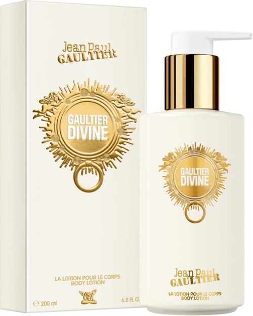Een witte bodylotionfles met gouden accenten en een bijpassende doos. Beiden hebben een cirkelvormig, zonachtig ontwerp met tekst.