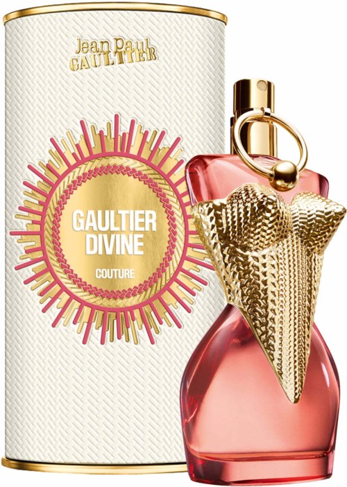Een parfumfles met een gouden kegelvormige dop en roze glas, naast een witte cilinder doos met goud en roze ontwerp.