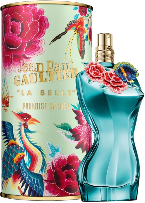 A perfume bottle with a floral design beside a container with colorful flowers and gold accents.