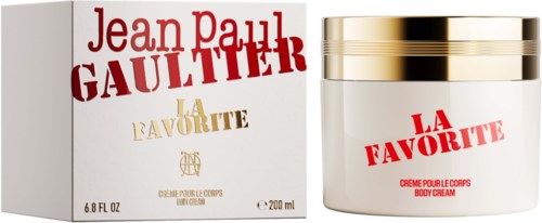 En vit burk med kroppslotion med gulddetaljer bredvid dess förpackning, båda märkt La Favorite av Jean Paul Gaultier.