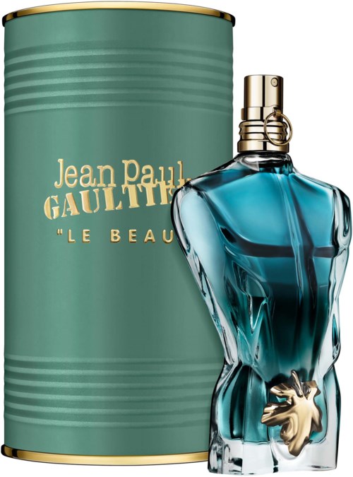 A fashion perfume bottle with a golden top and a lion-shaped charm, placed next to a green container for the scent.