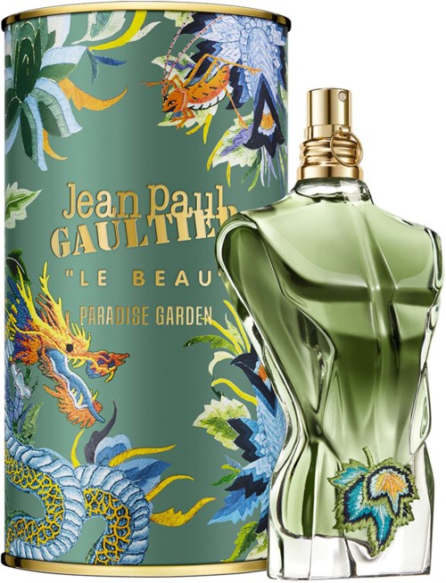 Eine Parfümflasche mit grünem Inhalt vor einer bunten Box mit Drachen und Pflanzen. Die Box hat goldenen Text.